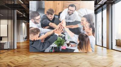 Happy business people team giving high five in office. Wall mural