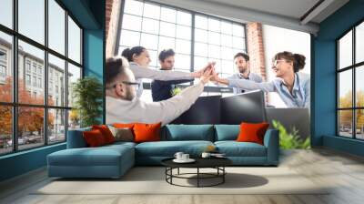 Happy business team giving high five in office. Wall mural