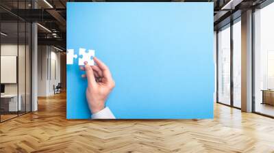 People holds in hand a jigsaw puzzle. Business solutions, success and strategy. Wall mural