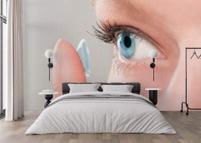 Woman inserting a contact lens in eye. Wall mural