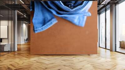 Fashionable stack of jeans, trouser, clothes on a texture backgr Wall mural