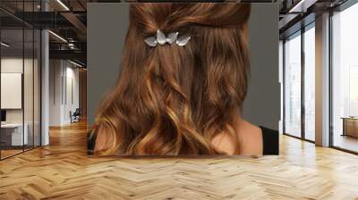 Close up isolated portrait of a young lady with wavy ombre hair. The back view of the girl with half-up half-down hairstyle, adorned with silver barrette. The woman posing over the grey background. Wall mural