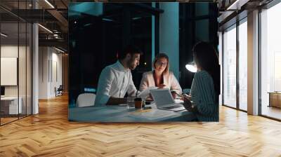 Teamwork, people and laptop in office at night with documents for deadline or overtime as accountant. Employee, partner and information for financial reviews, records and auditing in business report Wall mural