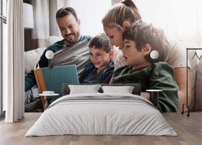 Relax, children and parents reading a book for bonding, fun and quality time. Knowledge, information and boys excited about learning a story together on the lounge sofa with their mother and father Wall mural