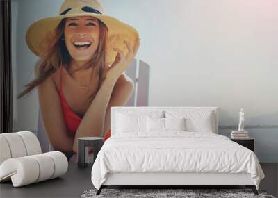 Portrait, beach and woman with hat, travel and smile for vacation, getaway trip and relax. Face, person and girl on chair, holiday and adventure with journey, water and summer with tropical island Wall mural