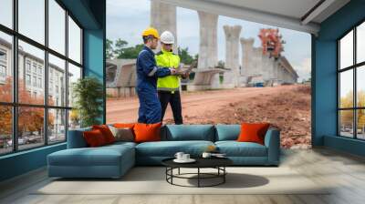 An Asian male engineer works at a motorway bridge construction site,Civil worker inspecting work on crossing construction,Supervisor working at high-speed railway construction site Wall mural