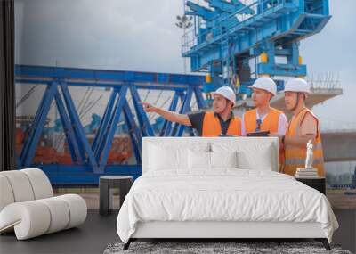 Group of asian engineers discuss about work at site of building under construction,The contractor team discusses the design of the structure,Three workers are working outside. Wall mural