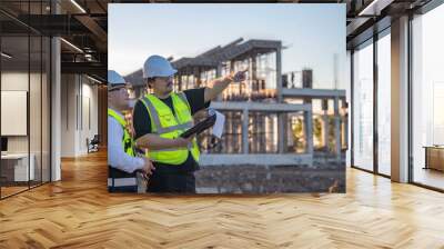 Two Asian engineer working at site of a large building project,Thailand people,Work overtime at construction site,Team of engineer discus at site Wall mural