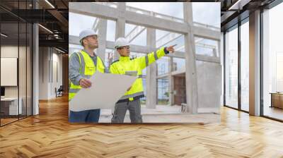 Two Asian engineer working at site of a large building project,Work overtime at construction site,Team of engineer discus at site,The architect, supervisor, and foreman meet to discuss the design Wall mural