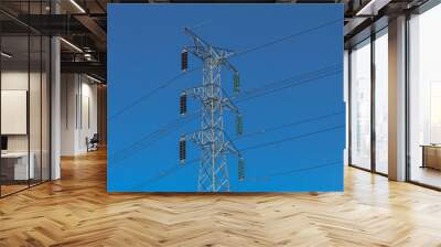 Close up of electricity tower transmission pylon with blue sky background Wall mural