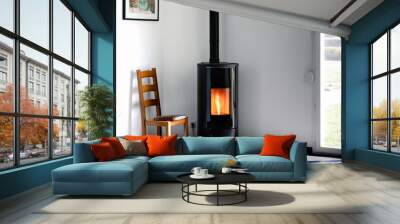 Modern black stove with burning flames and pellet bag in a living room Wall mural