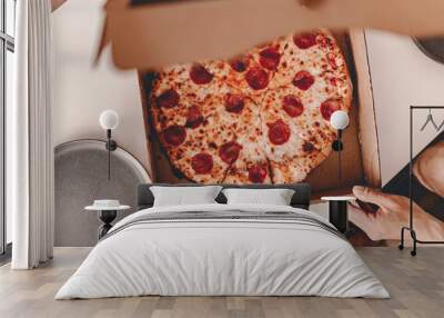 Food delivery. Ordering dinner online from the restaurant. New York style pizza and movie night. Family meal at home. Pepperoni and cheese topping. Cardboard box. Friday party. Comfort food. Wall mural