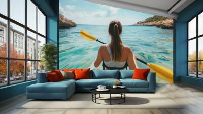 a girl on a transparent kayak swims in tropical waters against the backdrop of the islands Wall mural