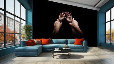 Man hands holding a woman hands for rape and sexual abuse concept isolated on black background Wall mural