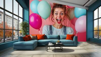 Portrait surprised young woman with colorful balloons pink background. Happy cheerful birthday celebration with fun party smile. Carefree joy adult female model holding helium air, positive expression Wall mural