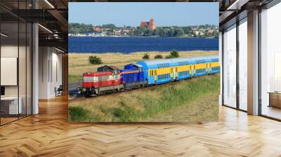 Passenger train hauled by the two locomotives against baltic sea Wall mural