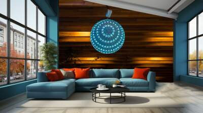 Blue round lamp with flowers pattern as a shade hanging against wooden background Wall mural