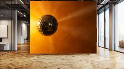 Golden disco ball with light rays on orange background with space for text. Wall mural