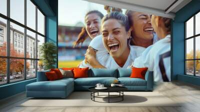 A group of Happy women's soccer team smiling and hugging each other celebrating wining the match on playing field Wall mural