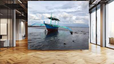 Beautiful view of a boat anchored by the sea on a bright, sunny, and cloudy day. Wall mural