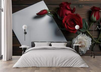 Flat lay Large white blank card note surrounded with red roses on dark wood table Wall mural