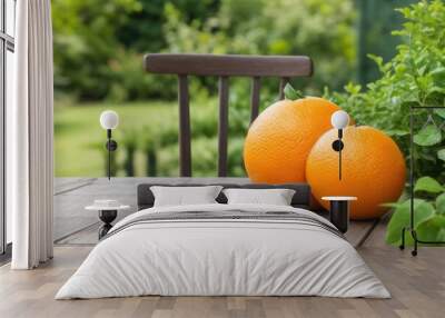 Orange on a wooden table over a blurry nature background Wall mural