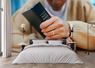 Hands, bible and prayer at desk, religion and Christian worship in home at table. Closeup, holy book and woman in meditation for God, Jesus and Christ for faith in spiritual gospel, praise or hope Wall mural