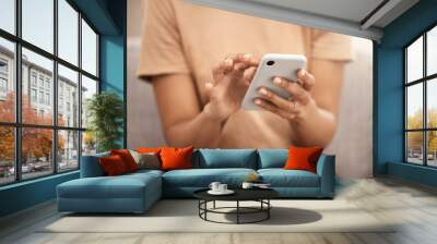 Hands, phone and woman typing on sofa in home living room, texting or scrolling social media. Tech, relax and female on couch in lounge on mobile smartphone networking or internet browsing in house. Wall mural