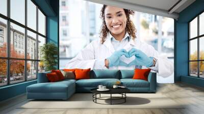 Woman, love and heart hands portrait in hospital for care, trust and support on valentines. Healthcare, dentist and happy black female doctor with hand gesture for affection, romance and kindness. Wall mural