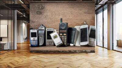 Old and obsolete mobile phone or cell phones on space of old wood background Wall mural