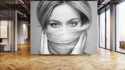 A beautiful woman who covered her mouth with hair, focus on the eyes. Wall mural