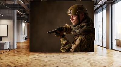 Portrait of a man equipped as a military man with an airsoft gun and helmet Wall mural