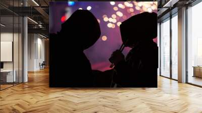 silhouette of two hooded men and fireworks in the background. selective focus blurred background Wall mural