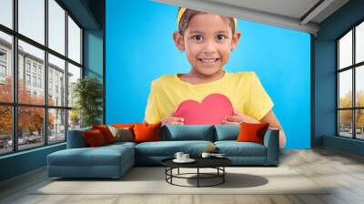 Portrait, smile and girl with heart cutout, joy and cheerful against a blue studio background. Face, Indian female child and kid with love symbol, excited and young person with sign, mockup and happy Wall mural