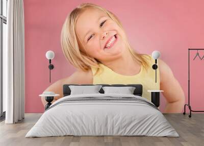 Smile, cute and portrait of a posing child isolated on a pink background in a studio. Happy, adorable and an excited young girl with happiness, smiling and excitement with a pose on a backdrop Wall mural