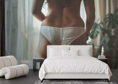 Beautiful young woman in white yellow swimming panties on bedroom background Wall mural