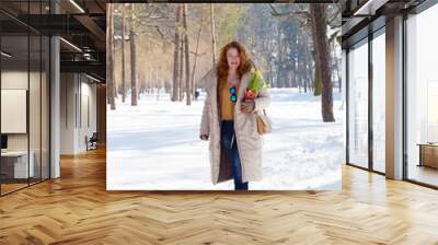 Charming red haired woman having a stroll in winter forest Wall mural