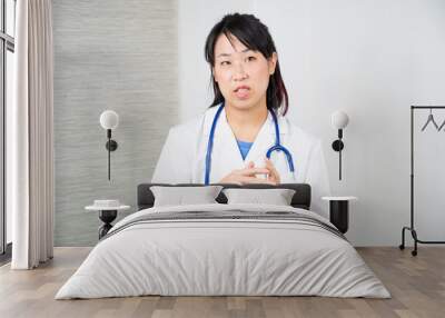 Asian female doctor during a consultation. Wall mural