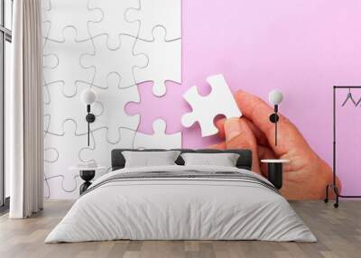 Hand placing white jigsaw puzzle piece. Horizontal composition with copy space. Wall mural