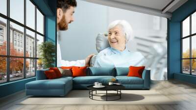 Beautiful elder woman with healthy smile sitting during the consultation with dentist at the dental office Wall mural