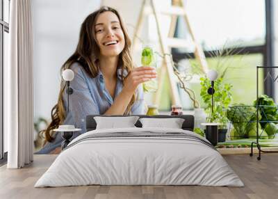 beautiful happy woman sitting with drinks and healthy green food at home. vegan meal and detox conce Wall mural