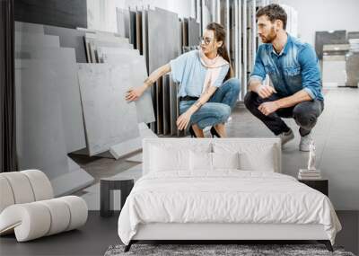 Beautiful young couple choosing big granite tiles for their house repairment in the building shop Wall mural