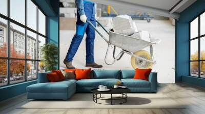 Builder carrying blocks on a wheelbarrow at the construction site indoors Wall mural