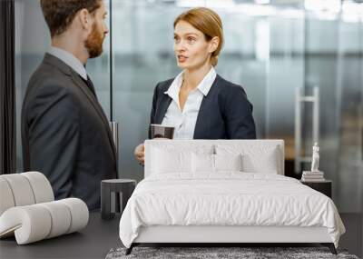 Business man and woman meeting in the hallway of the modern office building, white-collar workers having informal discussion Wall mural