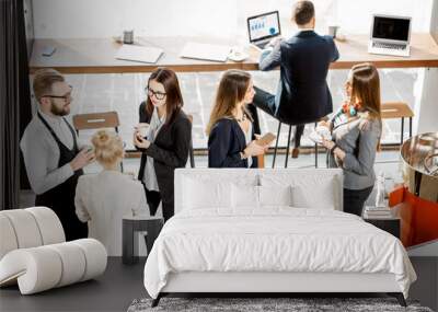 Business people having a conversation during the coffee break standing with waiter in the cafe Wall mural