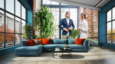 Business people having a conversation standing near the window in the beautiful loft interior Wall mural