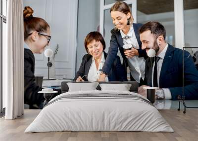 Business people working with charts and documents sitting at the table during the conference in the office Wall mural