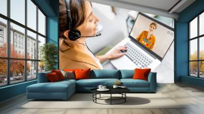 Business woman having a video call with coworker, working online from home at cozy atmosphere. Concept of remote work from home Wall mural