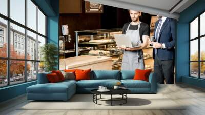 Businessman and barista working in the pastry shop Wall mural