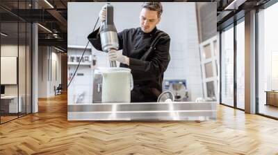 Chef cook mixing ingredients with professional blender, making a base for ice cream production at the kitchen or small manufacturing Wall mural